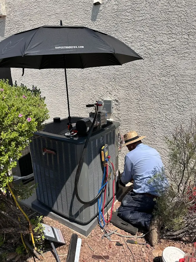 HVAC technician performing outdoor AC maintenance in Parker